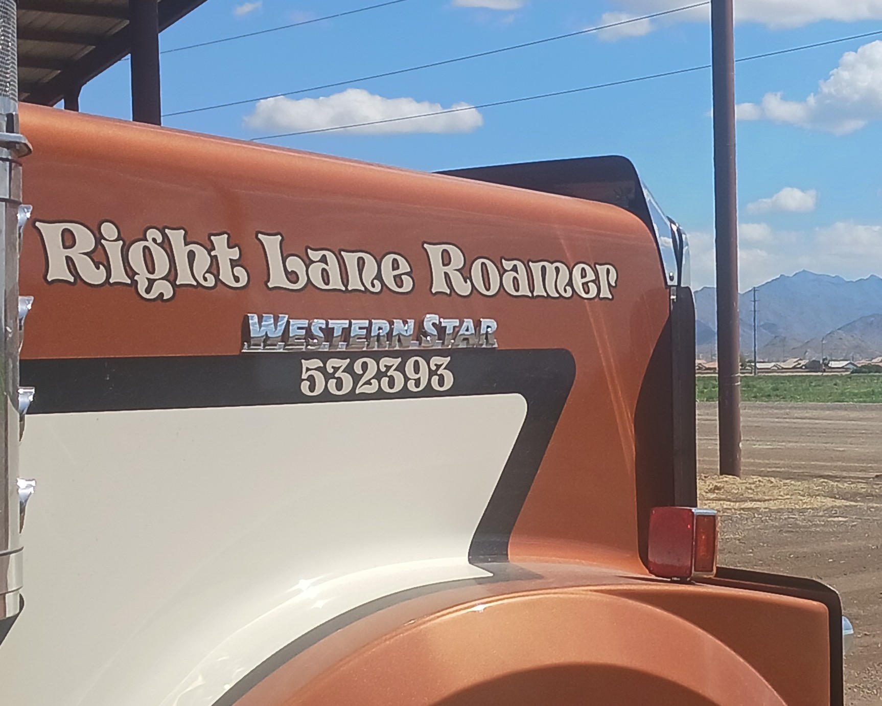Right Lane Roamer Western Star RV trailer with rust orange and cream exterior parked in rural landscape