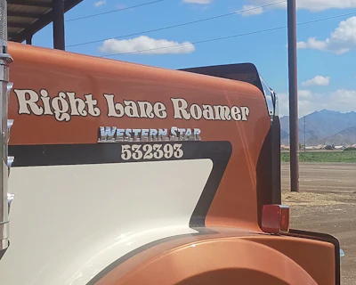 Right Lane Roamer Western Star RV trailer with rust orange and cream exterior parked in rural landscape