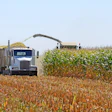 Combine harvester and grain truck harvesting corn in agricultural field