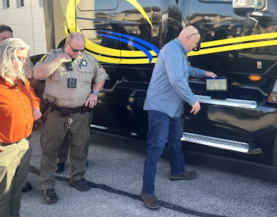 Law enforcement officer and civilians standing near vehicles during outdoor event or incident