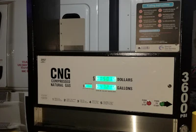 CNG fuel pump display showing price per gallon and total cost in cyan digital numbers at gas station