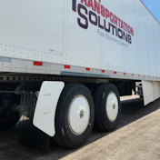 White semi-truck trailer with red and black Transportation Solutions branding and Fuel Economy Experts tagline