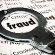 Handcuffs placed over newspaper headlines featuring crime and fraud-related text