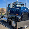 Vintage blue and black semi-truck with polished chrome details displayed at outdoor truck show