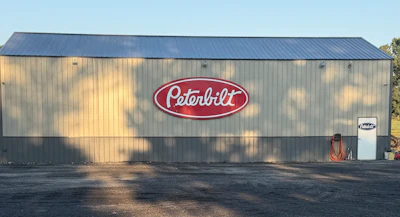 Peterbilt logo on industrial warehouse building with metal corrugated siding