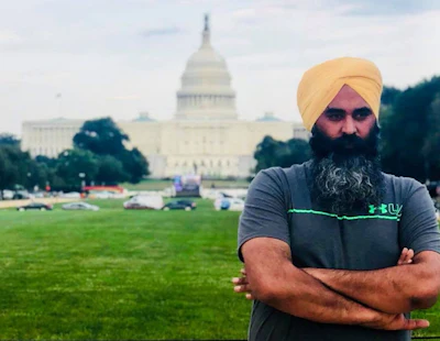 Man with yellow turban and beard standing before the U.S. Capitol Building with arms crossed