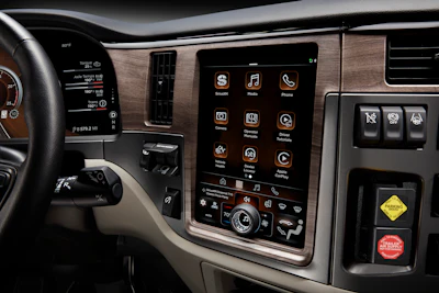 Vehicle dashboard with touchscreen infotainment system displaying apps and controls