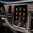 Modern vehicle dashboard with touchscreen infotainment system displaying app icons and controls