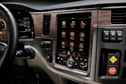 Modern vehicle dashboard with touchscreen infotainment system displaying app icons and controls