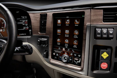 Modern vehicle dashboard with touchscreen infotainment system displaying app icons and controls
