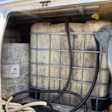 White van interior loaded with secured hay bales using black cargo straps and netting