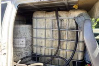 White van interior loaded with secured hay bales using black cargo straps and netting