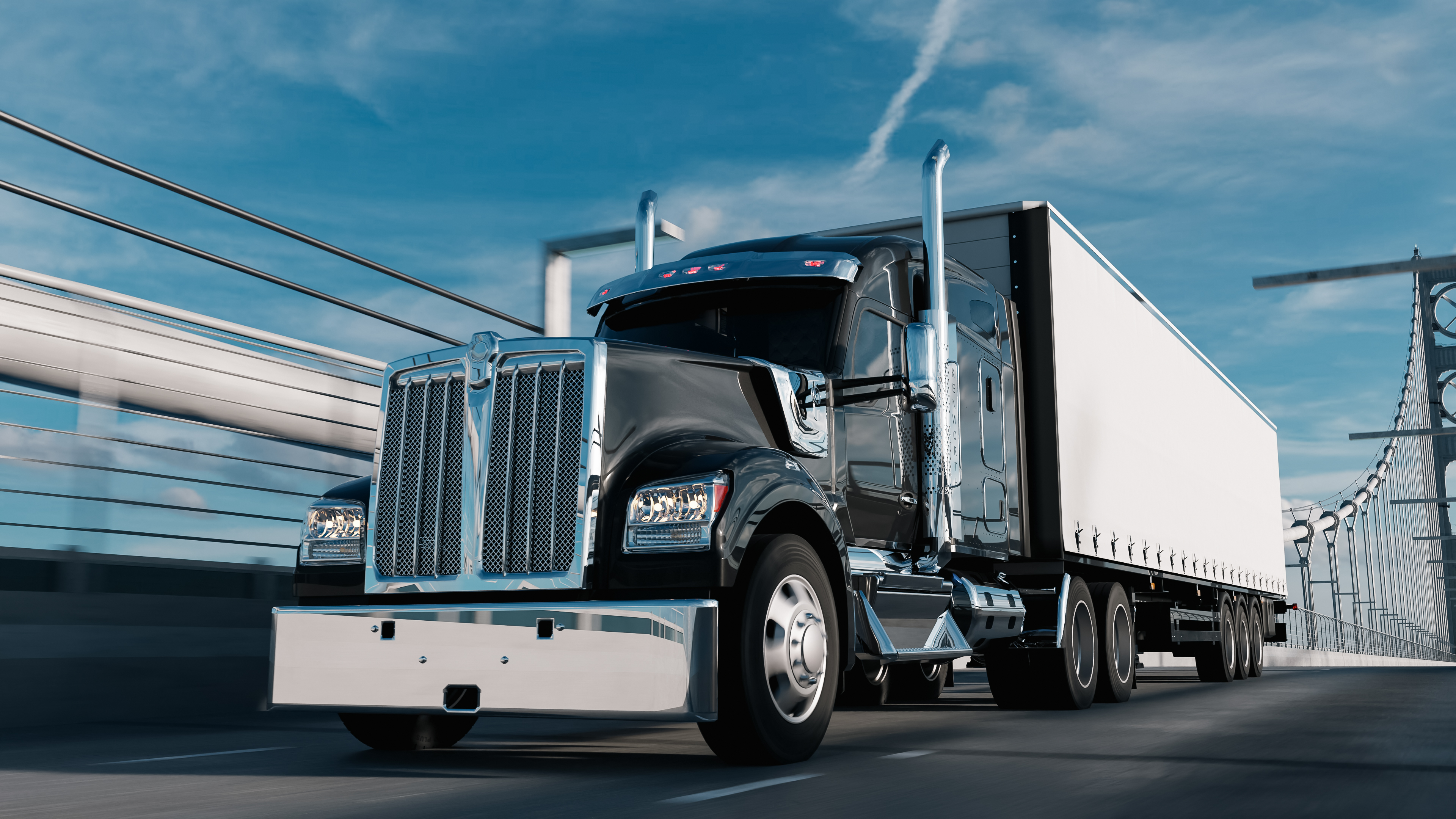Black and white semi-truck with cargo trailer driving on highway under blue sky
