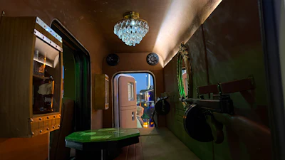 Retro-style kitchen interior with crystal chandelier, vintage refrigerator, green doors, and period furnishings