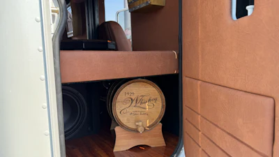 Wooden whiskey barrel dated 1929 displayed in RV interior with tan cabinetry