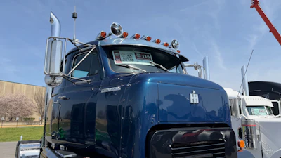 Blue International Harvester semi-truck with chrome details and roof lights parked outdoors
